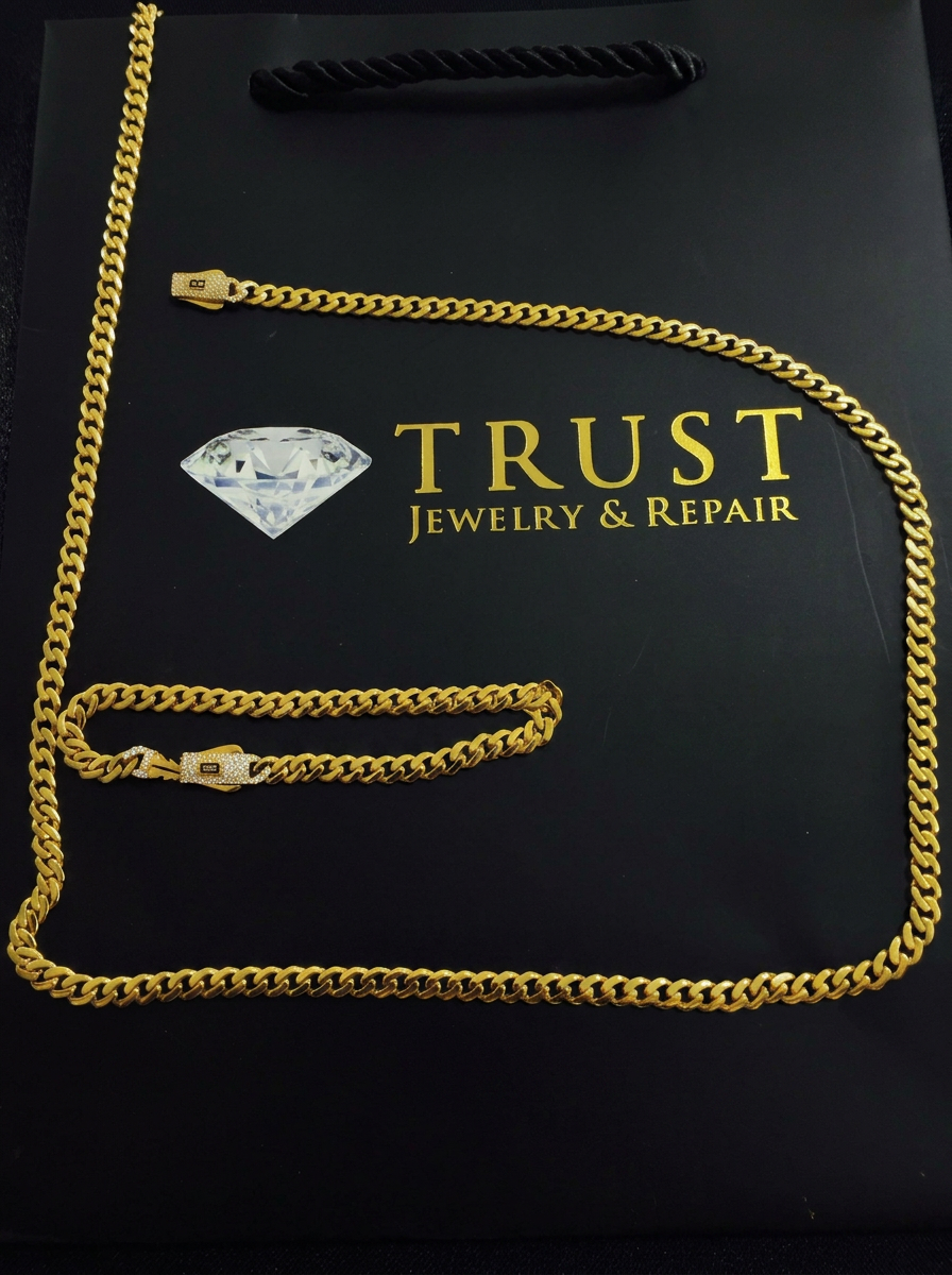 21K gold cuban chain and bracelet arranged on Trust Jewelry & Repair packaging